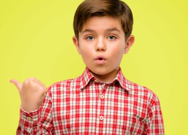 Mutlu ve sarı arka plan üzerinde yukarıyı ifade wow jest tezahürat yeşil gözlü yakışıklı yürümeye başlayan çocuk