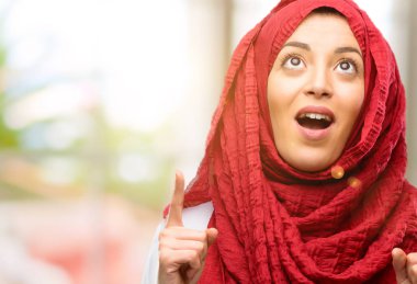 Mutlu ve yukarı dönük ifade wow jest tezahürat hijab giyen genç Arap kadın