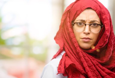 Hijab giyen genç Arap kadın rahatsız ve kızgın negatif duygu ifade, birisi ile rahatsız