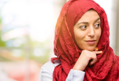 Soru ve şüphe ifade etmek acımak yüz ile düşünceli düşünme hijab giyen genç Arap kadın. Çözüm düşünün