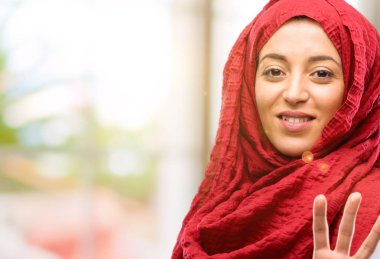 Onun parmak yükselterek hijab giyen genç Arap kadın olduğunu dört sayısı