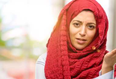 Hijab giyen genç Arap kadın rahatsız ve kızgın negatif duygu ifade, birisi ile rahatsız