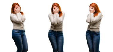 Confusedly geniş seyir elleriyle yüzünü kapsayan parmaklarının arasından, utangaç göz atmayı sahip gülümseyen genç güzel kızıl saçlı kadın