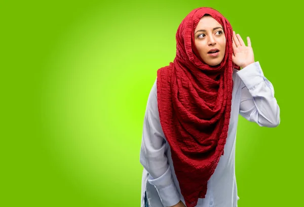 通信の概念やゴシップを表現する興味深いニュースを聞こうと耳の近くの手を握ってヒジャーブを着ている若いアラブ女性 — ストック写真