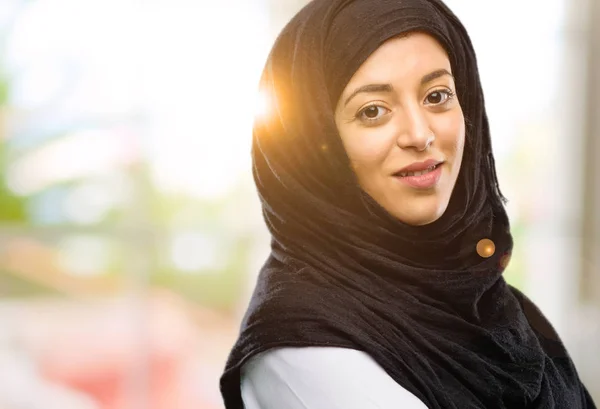 Young arab woman wearing hijab with crossed arms confident and happy with a big natural smile laughing