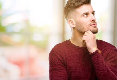 Yakışıklı genç adam düşünme ve şüphe ifade arıyorum ve merak ediyorum