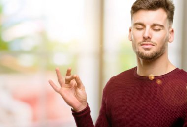 Meditasyon ve gevşeme ifade iki elinle ok işareti jest yapıyor yakışıklı genç