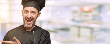 Kıdemli şef şapkalı bir şey lokanta mutfağı, boş elinde tutan adam, yemek