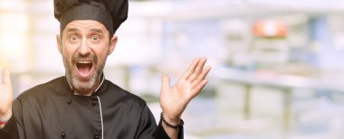 Kıdemli şef şapkalı mutlu ve ifade wow jest lokanta mutfağı, tezahürat adam, yemek