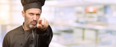 Kıdemli şef şapkalı açık lokanta mutfağı, parmakla işaret eden adam, yemek