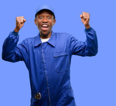 African black plumber man happy and excited celebrating victory expressing big success, power, energy and positive emotions. Celebrates new job joyful