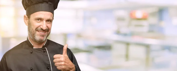 Homem Cozinheiro Sênior Usando Chapéu Chef Sorrindo Amplamente Mostrando Polegares — Fotografia de Stock