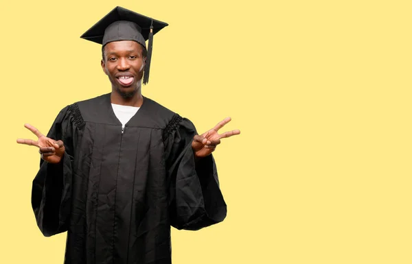 ブラック アフリカの若い大学院生男の指でトンと勝利のサインを表示するカメラを見て — ストック写真