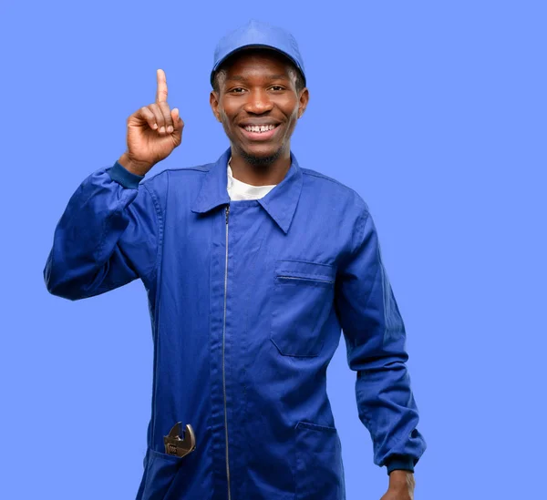 African black plumber man happy and surprised cheering expressing wow gesture pointing up