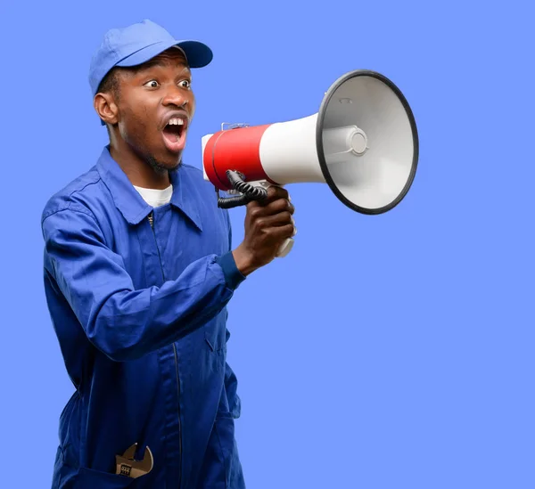 African black plumber man communicates shouting loud holding a megaphone, expressing success and positive concept, idea for marketing or sales