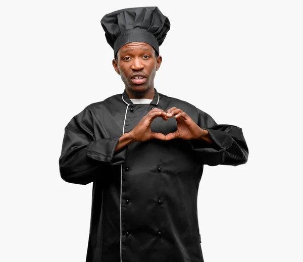 年轻的黑厨师戴着厨师帽快乐地显示爱与手在心脏形状表达健康和婚姻标志 — 图库照片