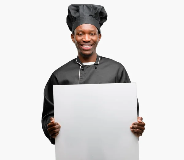 年轻的黑色厨师戴着帽子 拿着空白的广告横幅 好广告海报 提供或公告 大纸广告牌 — 图库照片