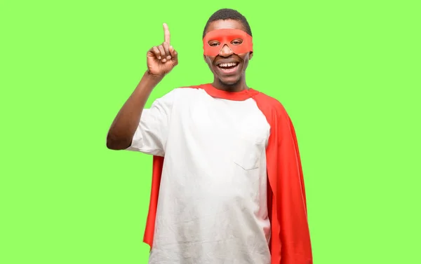 指でアウェイ側を指しているアフリカの黒のスーパー ヒーロー男 — ストック写真