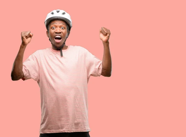 バイク ヘルメット幸せと興奮祝う勝利大成功 エネルギーおよび肯定的な感情を表現することを身に着けている黒人男性 新しい仕事の喜びを祝う — ストック写真