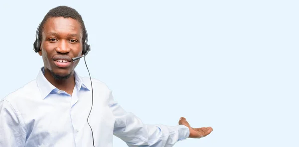 Black man consultant of call center confident and happy with a big natural smile inviting to enter