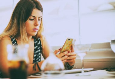 Restoranda Smartphone kullanan genç kadın