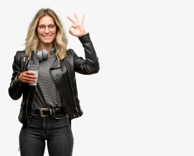 Genç öğrenci kadın meditasyon ve gevşeme ifade iki elinle ok işareti jest yapıyor kulaklıklar ile