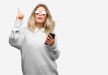 Smartphone mutlu ve yukarı dönük ifade wow jest tezahürat kullanan genç güzel kadın