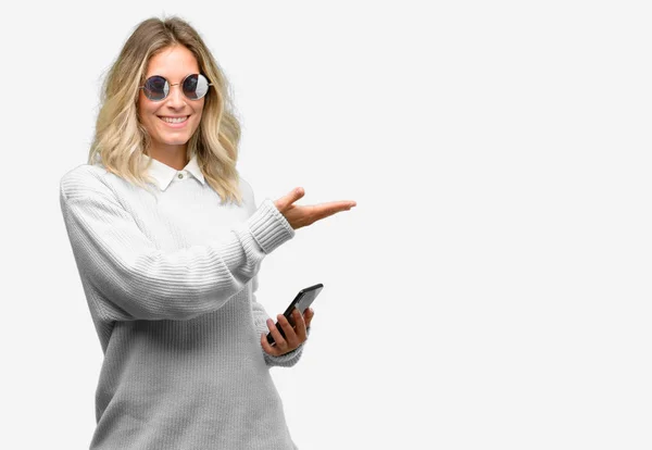 Νεαρή Όμορφη Γυναίκα Χρησιμοποιώντας Smartphone Κρατώντας Κάτι Στο Άδειο Χέρι — Φωτογραφία Αρχείου
