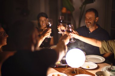 Güzel bir aile terasta bir bardak şarapla kadeh kaldırıyor.