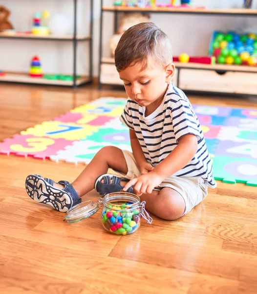 Vackra Småbarn Pojke Sitter Pussel Äta Små Färgade Chokladbollar Dagis — Stockfoto