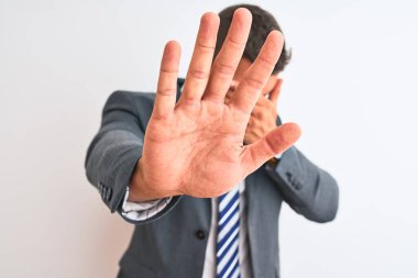 Takım elbiseli ve kravatlı genç yakışıklı iş adamı ellerle gözleri kapatıyor ve üzgün ve korku ifadeleriyle jestleri durduruyor. Utanç verici ve olumsuz bir kavram..