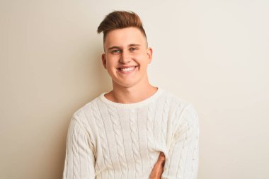 İzole edilmiş beyaz arka plan üzerinde duran, kollarını kavuşturup kameraya bakan yakışıklı genç bir adam. Pozitif kişi.