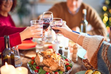Mutlu ve kendinden emin gülümseyen güzel bir aile. Kızarmış hindi yemek ve evde Noel 'i kutlamak için bir bardak şarapla kadeh kaldırmak.
