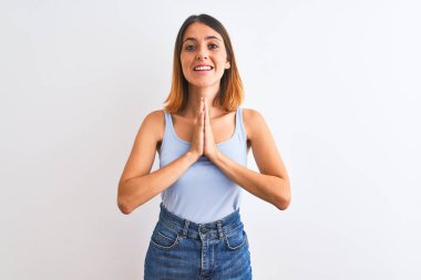 Güzel kızıl saçlı kadın, izole edilmiş arka planda duruyor. Elleri birarada dua ediyor, af diliyor..