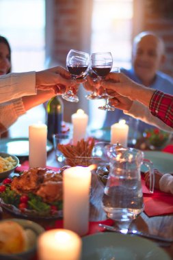 Mutlu ve kendinden emin gülümseyen güzel bir aile. Kızarmış hindi yemek ve evde Şükran Günü 'nü kutlamak için bir bardak şarapla kadeh kaldırmak.