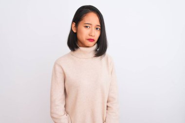 Balıkçı yaka kazak giyen genç bir kadın izole edilmiş beyaz arka planda dikiliyor. Depresyonda ve endişe içinde, kızgın ve korkmuş bir şekilde ağlıyor. Üzücü ifade.