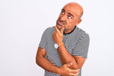 İzole edilmiş beyaz arka plan üzerine çizgili bir tişört giyen orta yaşlı yakışıklı bir adam bir soru hakkında endişeli ve gergin bir şekilde düşünüyor.