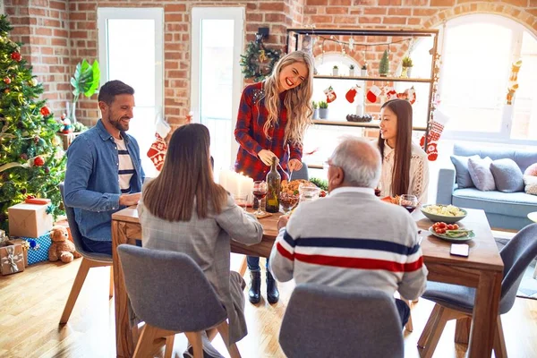 Beautiful family meeting smiling happy and confident. Carving roasted turkey celebrating Christmas at home