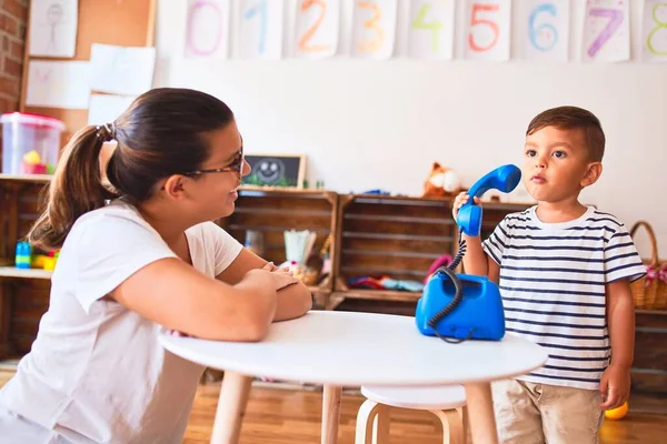 Güzel Öğretmen Küçük Çocuk Anaokulunda Klasik Mavi Telefonla Oynuyor — Stok fotoğraf