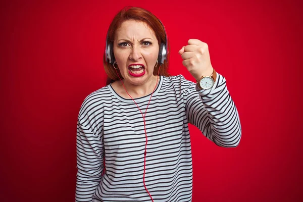Mujer Pelirroja Joven Escuchando Música Usando Auriculares Sobre Fondo Rojo —  Fotos de Stock