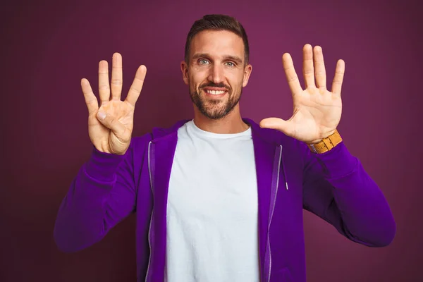 Young fitness man wearing casual sports sweatshirt over purple isolated background showing and pointing up with fingers number nine while smiling confident and happy.