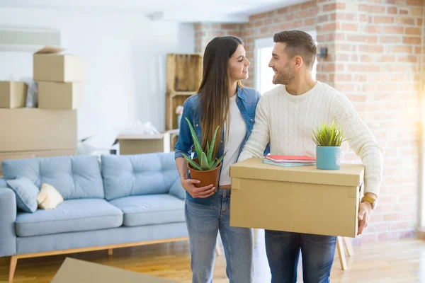 Hermosa joven pareja mudándose a una nueva casa, sonriendo feliz espera —  Fotos de Stock