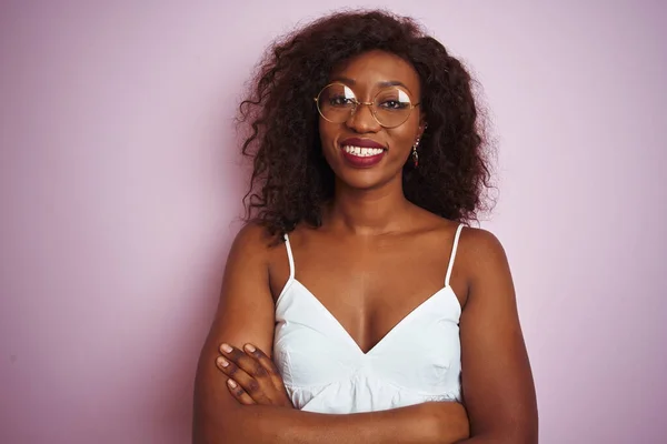 年轻的非洲裔美国女人戴着眼镜 站在孤立的粉色背景上开心地微笑着 交叉着双臂看着相机 积极的人 — 图库照片