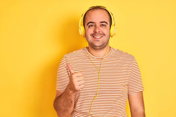 Kulaklıkla Müzik Dinleyen Genç Bir Adam Izole Edilmiş Sarı Arka — Stok fotoğraf