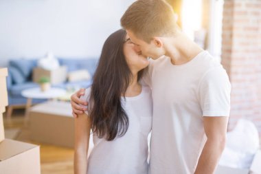 Karton kutuların etrafında duran genç ve güzel bir çift.