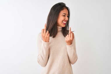 Balıkçı yaka kazak giyen güzel Çinli kadın izole edilmiş beyaz arka planda dikiliyor orta parmağını göstererek kötü ifade, provokasyon ve kaba tavır sergiliyor. Heyecanlı çığlık