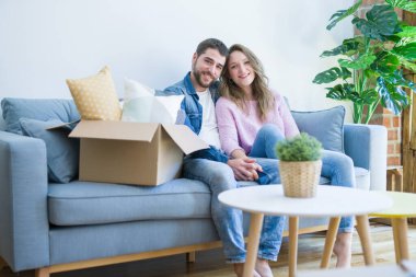 Genç çift içinde aşk sarılma oturma üzerinde the kanepe çok mutlu MOVI