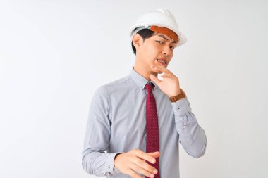 Kravat ve kask takan Çinli mimar, izole edilmiş beyaz arka planda duruyor, tiksindirici ve tiksindirici bir ifade takınıyor çünkü tiksinti tepkisi veriyor. Eller havada. Can sıkıcı bir kavram..
