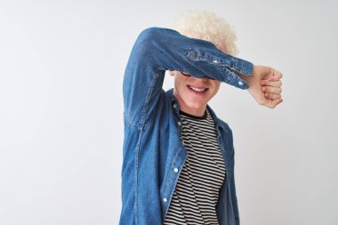 Kot gömlek ve gözlük takan genç albino sarışın adam izole edilmiş beyaz arka plan üzerine gözleri kapayarak neşeli ve komik bir şekilde gülümsüyor. Kör kavram.