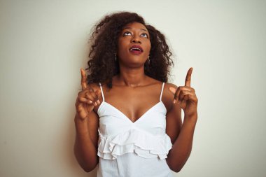 Genç Afro-Amerikalı kadın tişört giyiyordu. İzole edilmiş beyaz arka plan üzerinde duruyordu. Şaşırmış ve şaşırmıştı..